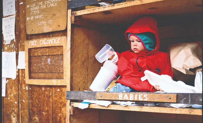 A baby sits in the free bin at a ski mountain.