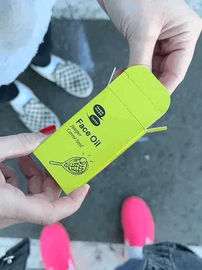A mini vial is pulled out of a green box