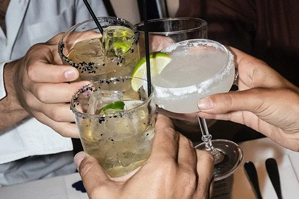 Guests toasting with cocktails at Ace Hotel & Swim Club Athens, celebrating the opening of Sebastian, the hotel's new restaurant.