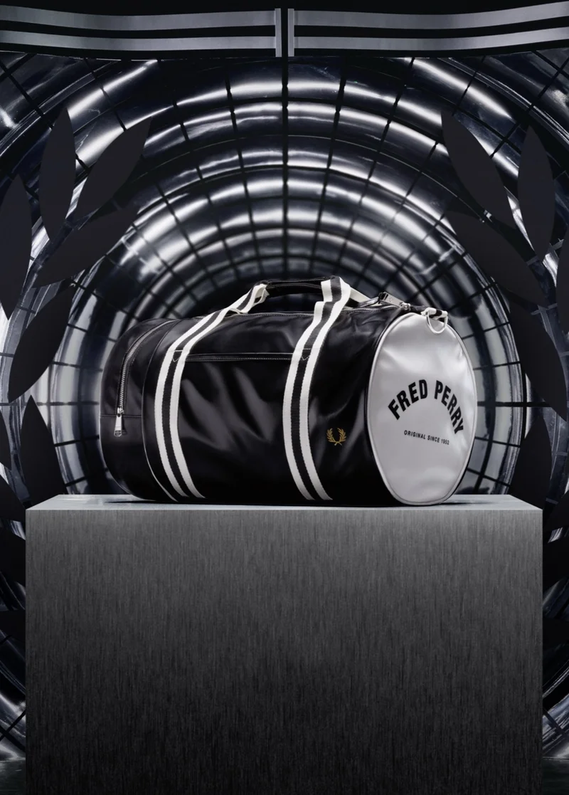 A photograph of our classic black and white barrel bag sitting on top of a podium