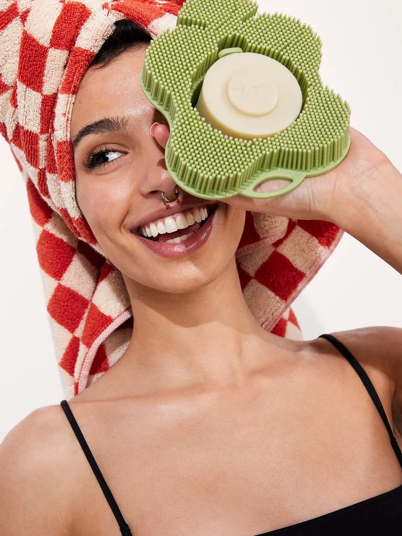 Women holding a sage smoosh in front of her face