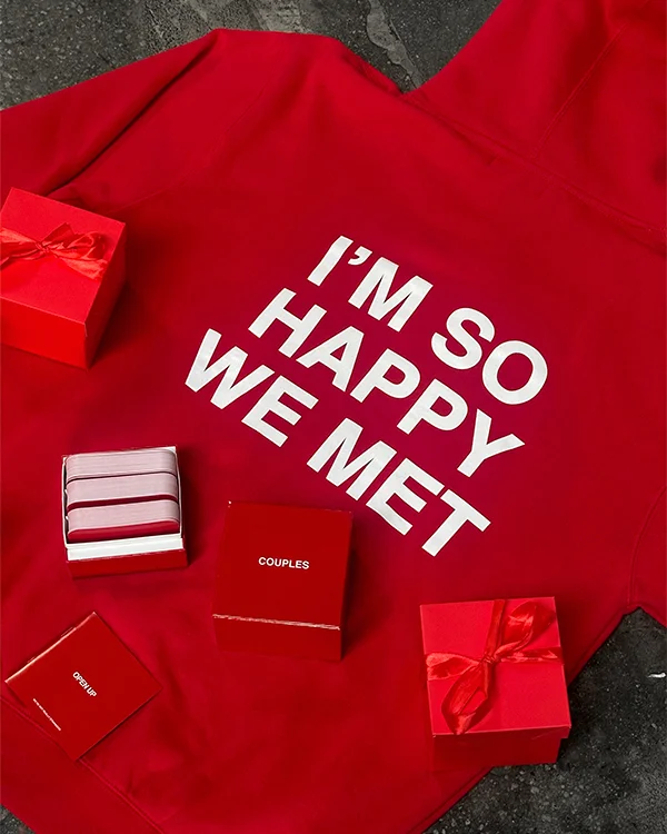 image of the We're Not Really Strangers I'm So Happy We Met hoodie in red with Couples game and holiday boxes