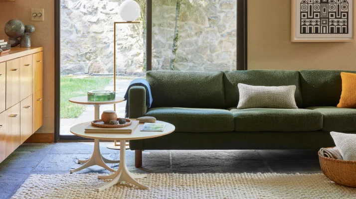 Living room environment with a three-seater Lispenard Sofa in dark green fabric with 6 inch walnut legs and Nelson Tables in walnut.