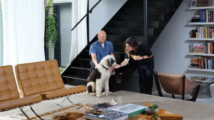 Owners Tereasa Surratt and David Hernandez are pictured in the Brick Weave House living room area with two Barcelona Chairs and an eclectic coffee table in the forefront.