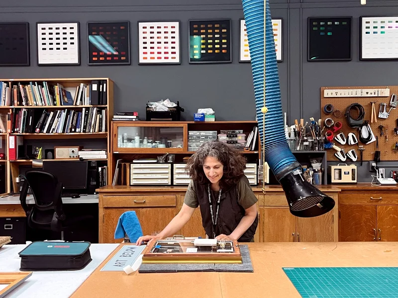A photograph of a woman examining objects in a conservation lab