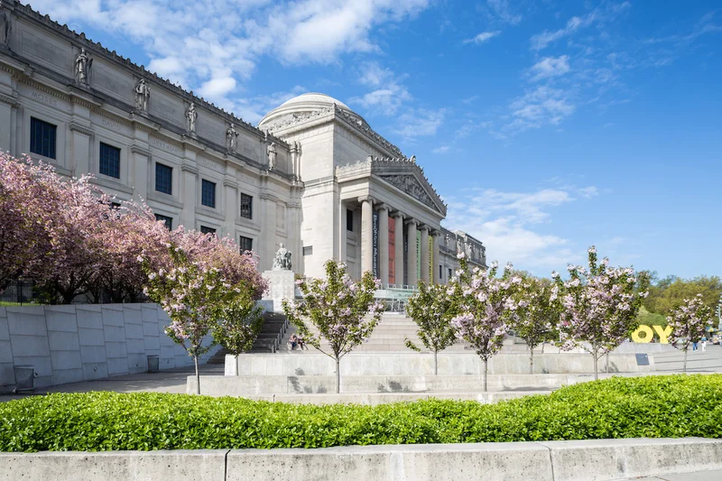 A photograph of the Brooklyn Museum surrounded by flowers