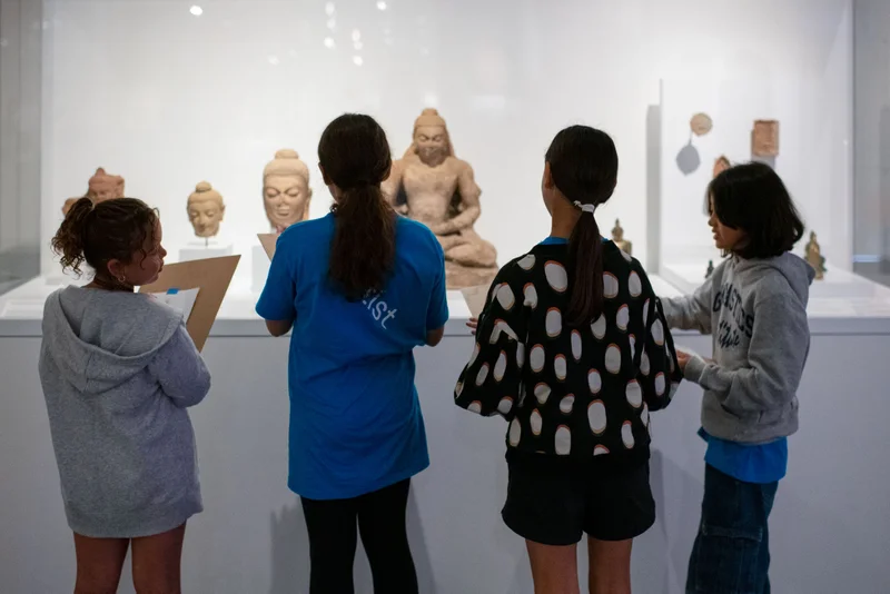A photograph of children looking at art