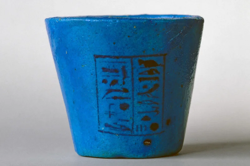A blue cup with hieroglyphics