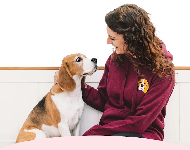 Beagle sitting with it's owner who's wearing a custom hoodie