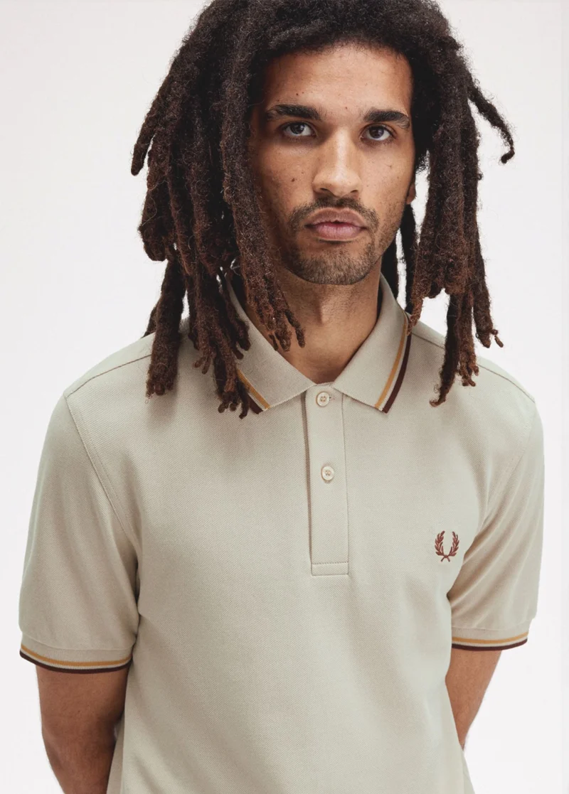Man wearing beige, twin tipped Fred Perry polo shirt