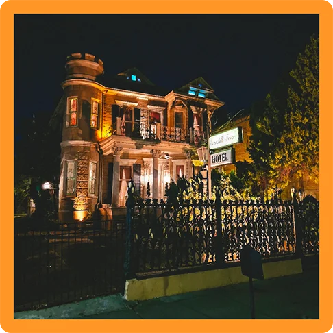 Image description: The exterior of an old hotel at night.