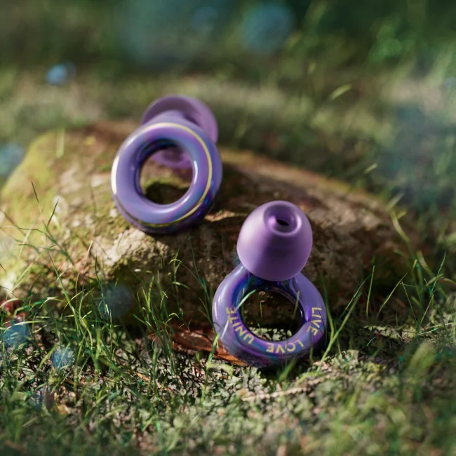 Close-up shot of the Loop x Tomorrowland Experience 2 earplugs in green grass.