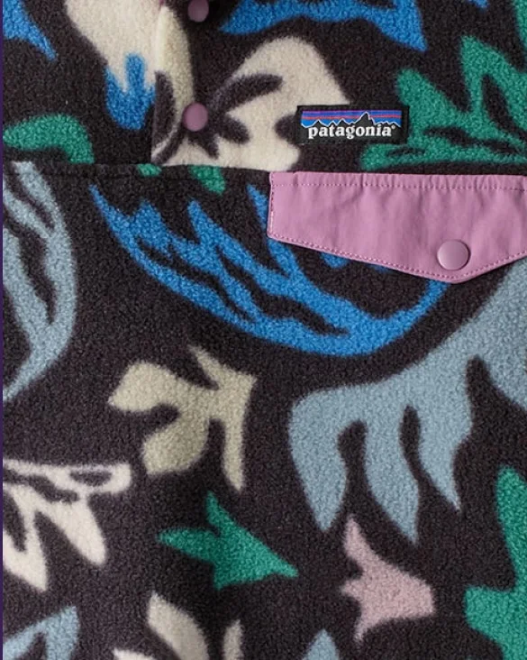 A person places construction paper cutouts on a white piece of paper to make a design.