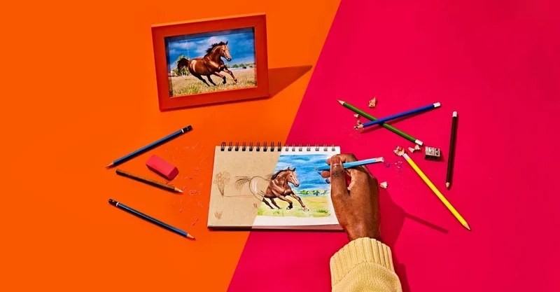 Image drawing a horse on a notebook and different pencils spread around