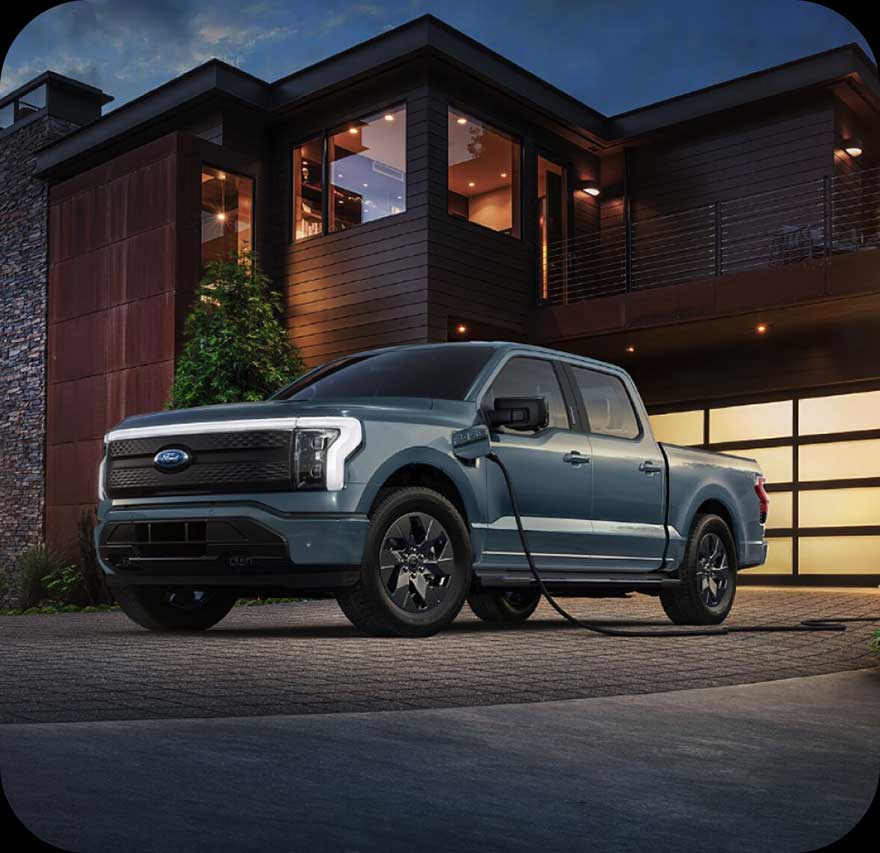 A Ford F‑150 Lightning parked outside a house.