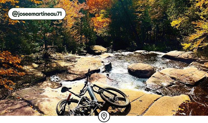 Image description: Mountain bikes laying by a waterfall in Vallée Bras-du-Nord, photo taken by @joseemartineau71