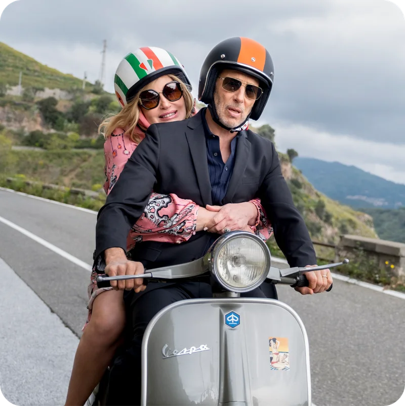 Still from The White Lotus in Sicily, featuring two of the characters on a vespa