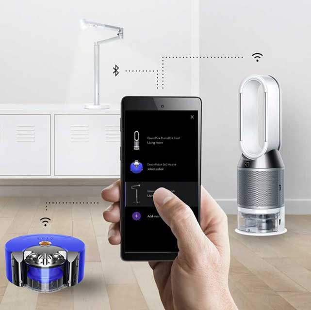 Hand holding a smartphone showing how it is connected to a robot vacuum, air purifier and light.