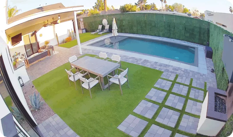 Point-of-view image of a backyard with pool.