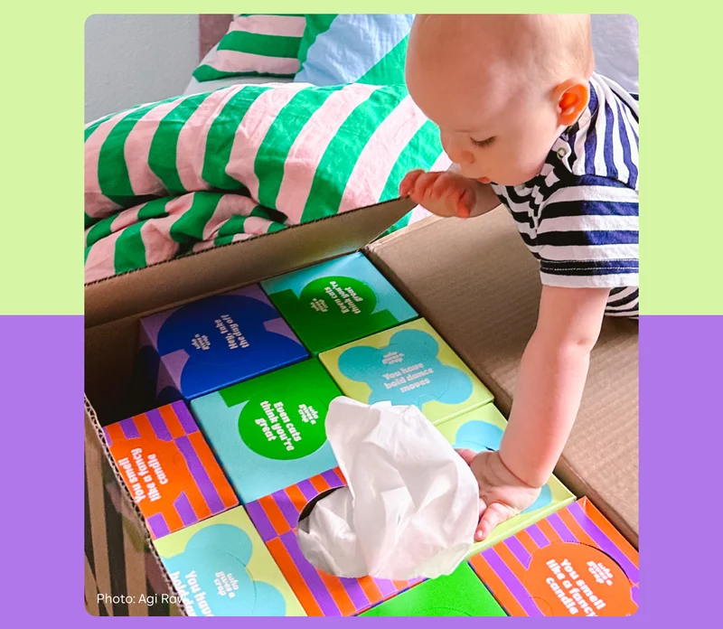 Image: Baby opening a box of Who Gives A Crap tissues.