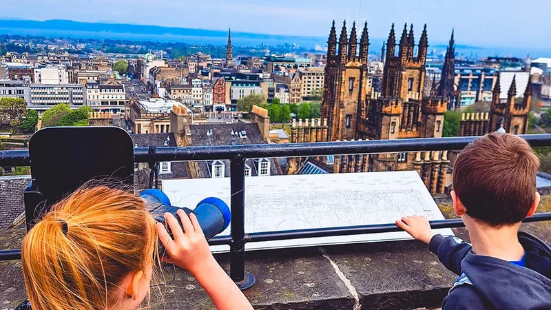 Image description: Two kids viewing Edinburgh from rooftop at Camera Obscura and World of Illusions.