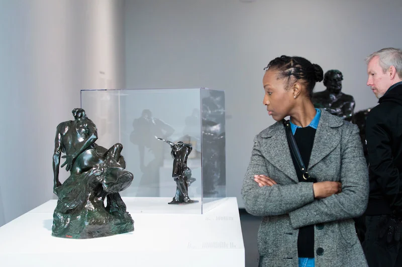 A woman looking at a bronze sculpture