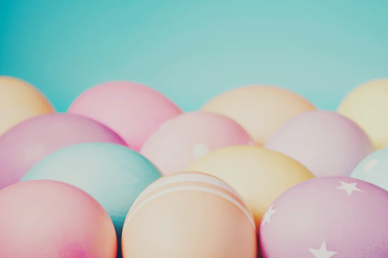 Pastel-colored Easter eggs against a blue background
