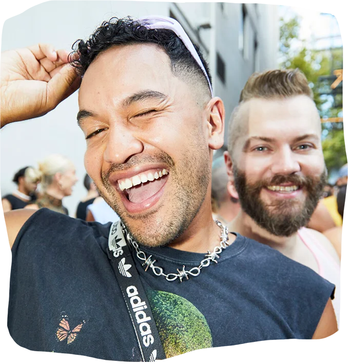 A cheerful photo from the 'Sydney Mardi Gras' celebration, with one person smiling broadly, capturing the festive spirit of the LGBTQIA+ event through March 3.