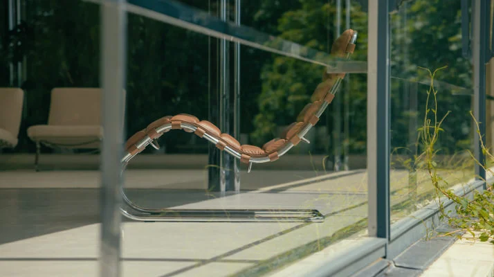 View of MR Chaise Lounge in Chestnut Leather through glass and steel window of Tugendhat Villa
