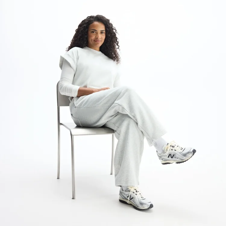 Sydeon sitting in chair pictured in head-to-toe New Balance apparel and 204L shoes (U204LSWD)