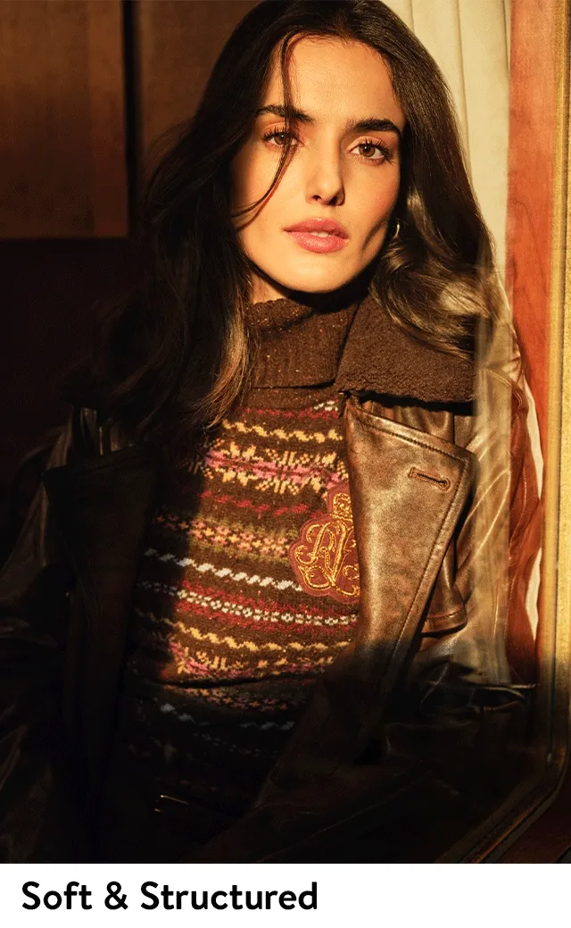 A woman wearing a turtleneck sweater and leather jacket. A woman wearing a suit with a floral-print blouse.