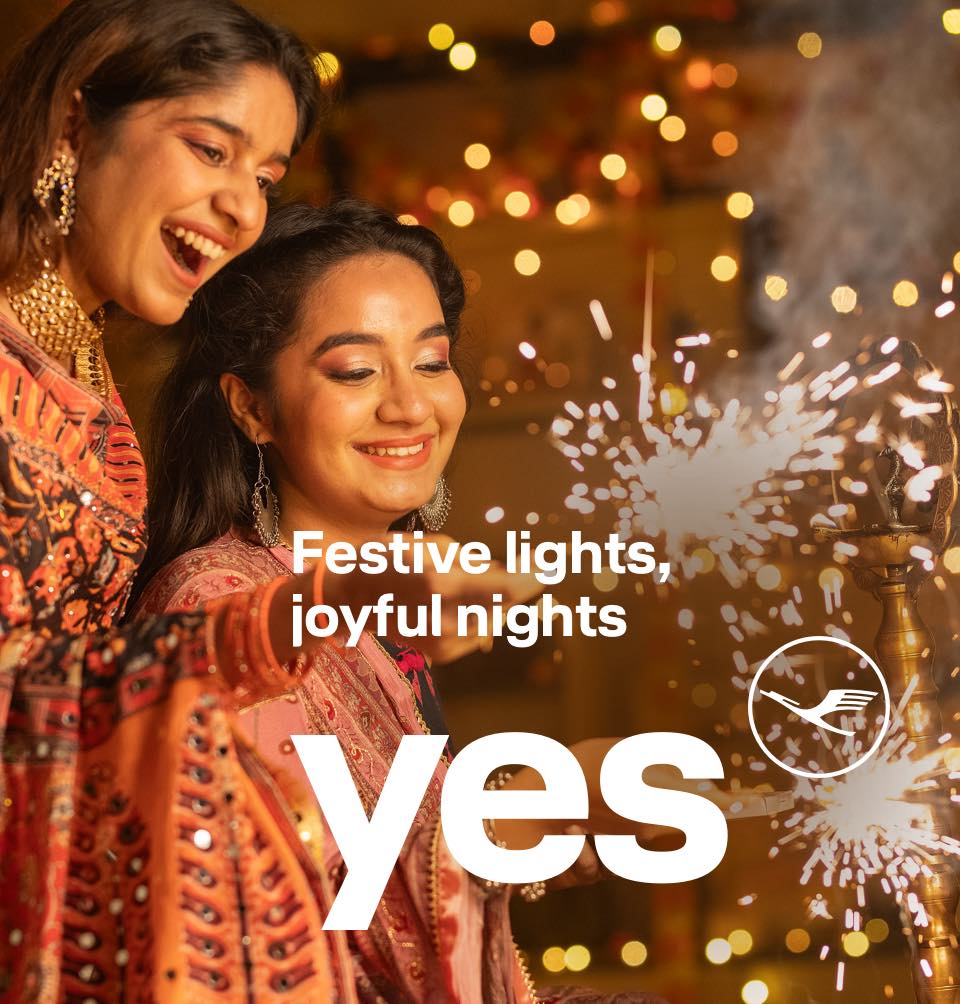 Two women look down happily at the sparks from their fireworks.