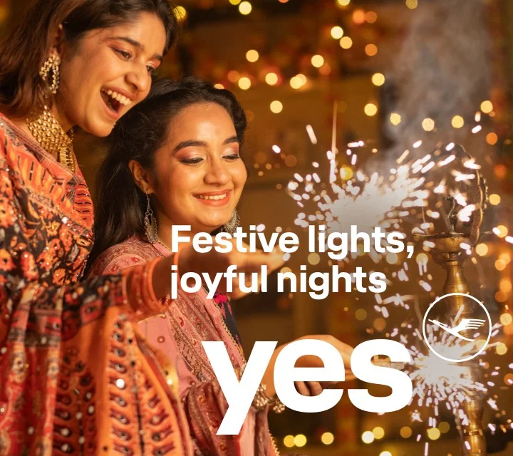 Two women look down happily at the sparks from their fireworks.