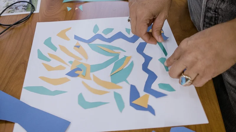A designer creates a print with paper cut outs.