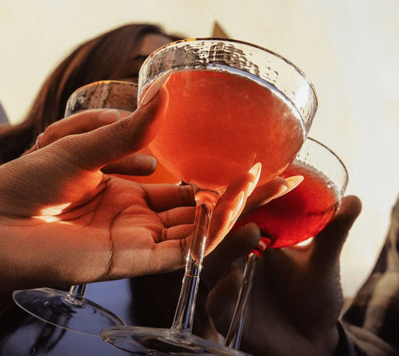 (image of three hands cheersing glasses of strawberry guava, blackberry lemon, and watermelon lime hiyo.)