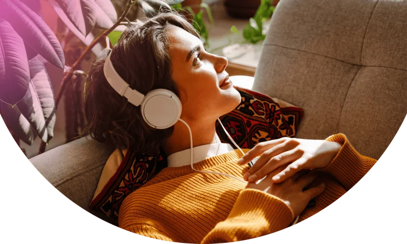 Woman with eyes closed listening to Calm through wireless headphone