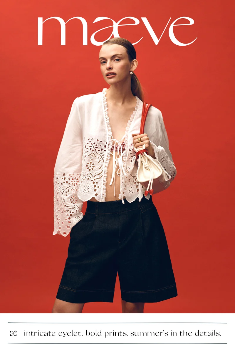 Woman wearing white blouse and black shorts. Shop intricate eyelet, bold prints, summer's in the details