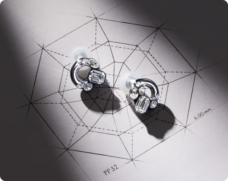 A pair of Swarovski x Loop earplugs resting on a sketch.