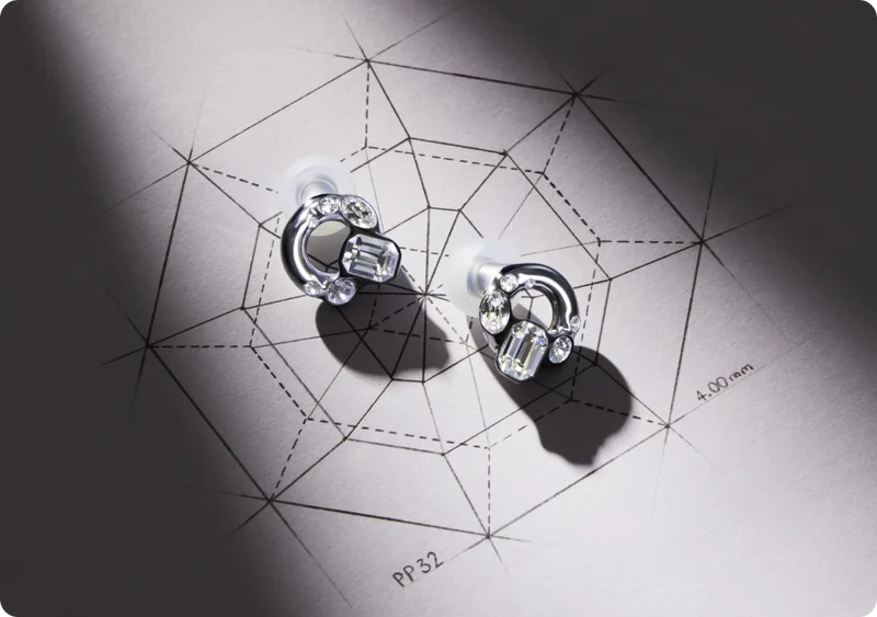A pair of Swarovski x Loop earplugs resting on a sketch.
