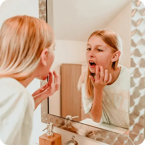 tween girl doing skincare routine in mirror tween girl doing skincare routine in mirror