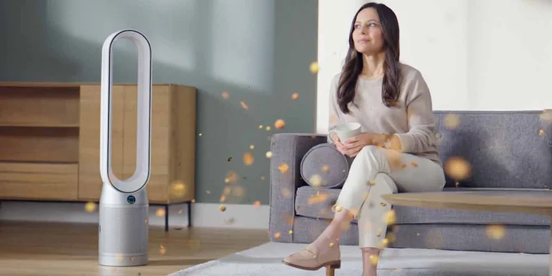 Woman next to a Dyson purifier.