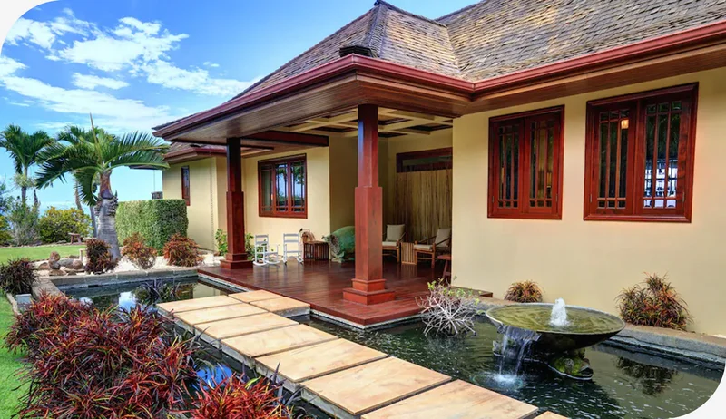 Warm island home with wood details, lush greenery, and a sunlit patio in Maui.