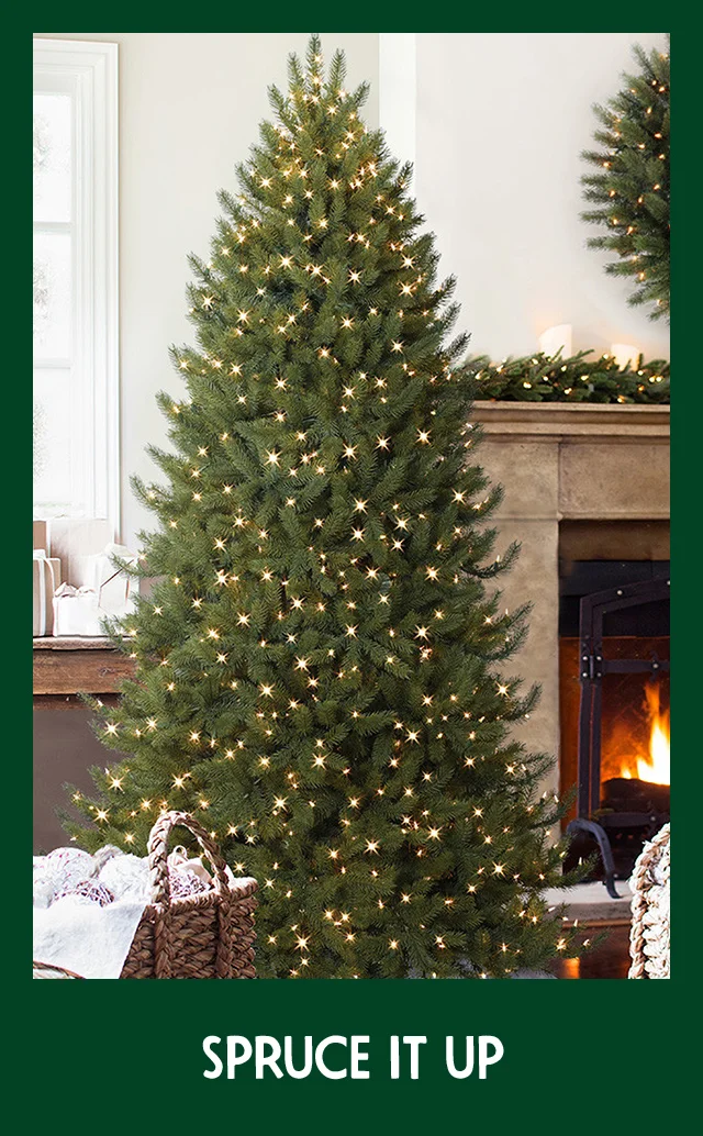 A room decorated with a lit Christmas tree, wreath and garland.