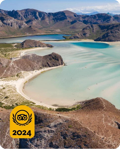Image Description: A light blue ocean surrounded by sand and mountains. A gold Travelers’ Choice Awards Best of the Best 2024 badge is on the bottom left corner.