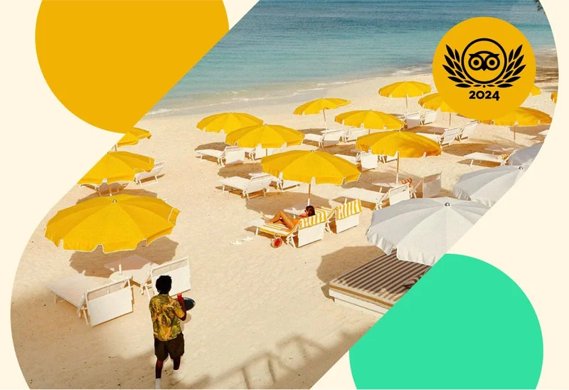 Image Description: A person walking with a drink towards yellow umbrellas on a sandy beach. A gold Travelers’ Choice Awards Best of the Best 2024 badge is on the top right corner.