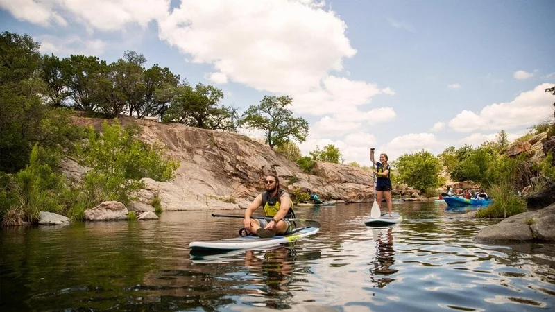 Image description: People kayaking and paddleboarding Inks Lake in Texas