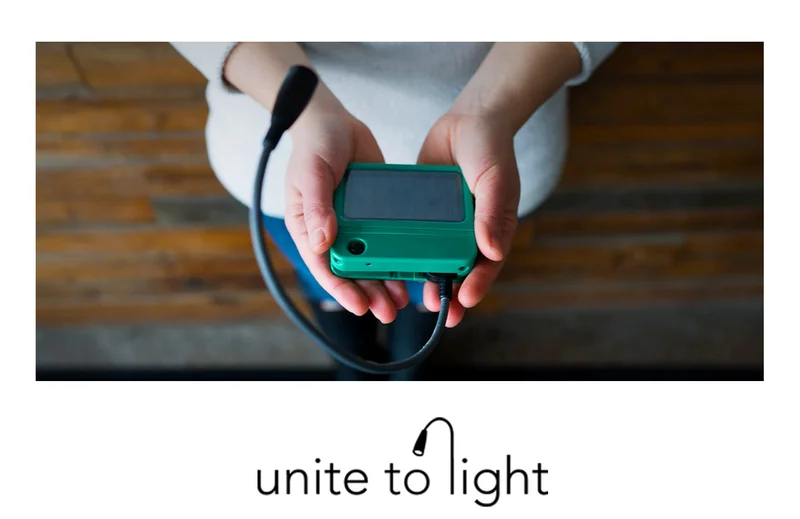 Unite to Light (image: a person holding a green handheld solar light)