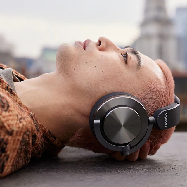A model wearing Dyson OnTrac headphones while laying down