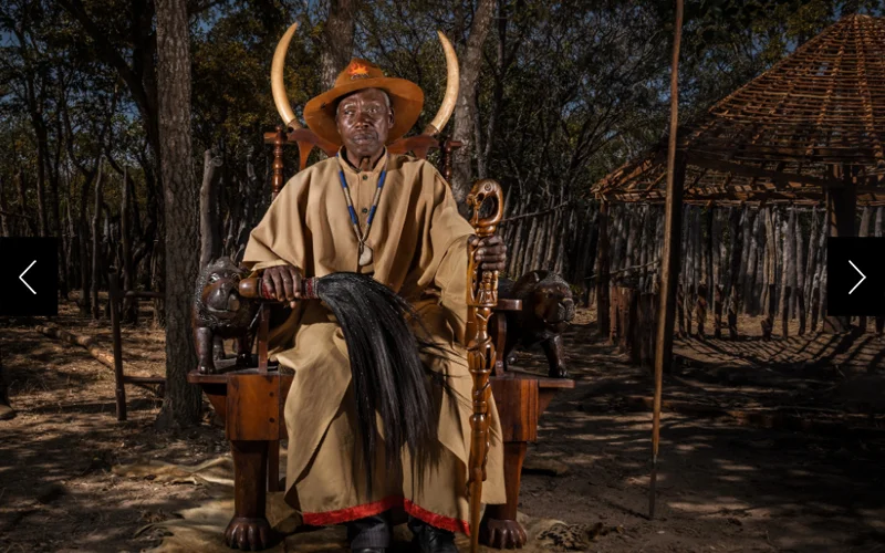 Mwene Chivueka VI, king of the Luchazi, sits on his throne.
