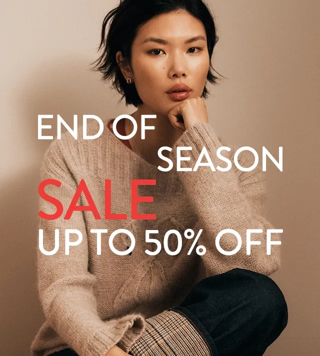 End-of-season sale: up to 50% off. A woman wearing a cozy sweater.